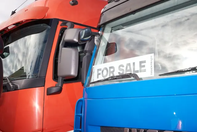 Zwei Lastwagen mit For-Sale-Schild in der Windschutzscheibe