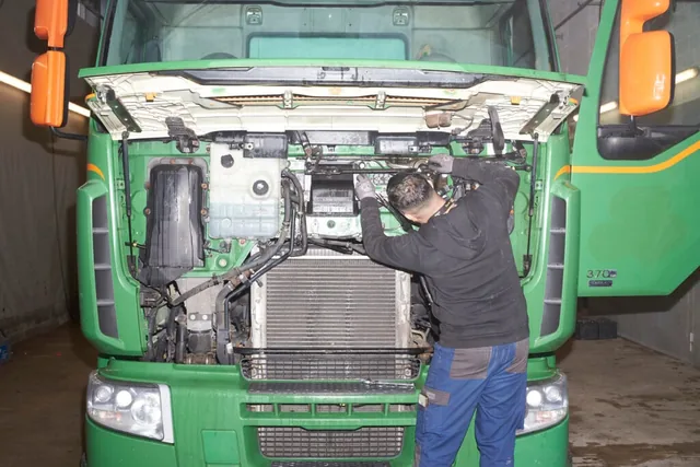 Mechaniker bei der Wartung am geöffneten Frontdeckel eines Lastwagens